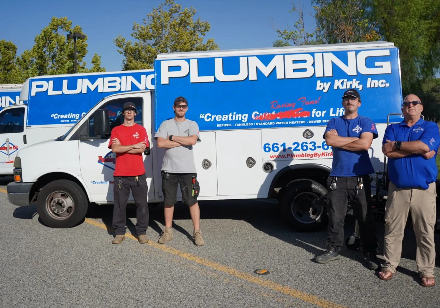 Four members of the Plumbing by Kirk crew standing in front of one of the company's box trucks